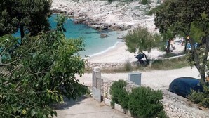 Un quartier résidentiel situé sur la côte, avec une route asphaltée menant à une plage.