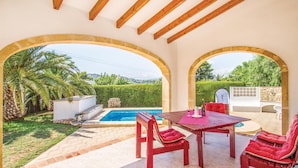 A covered outdoor area with a pool, red furniture, and a view of the landscape. - Stunning home in Jávea (Jávea)