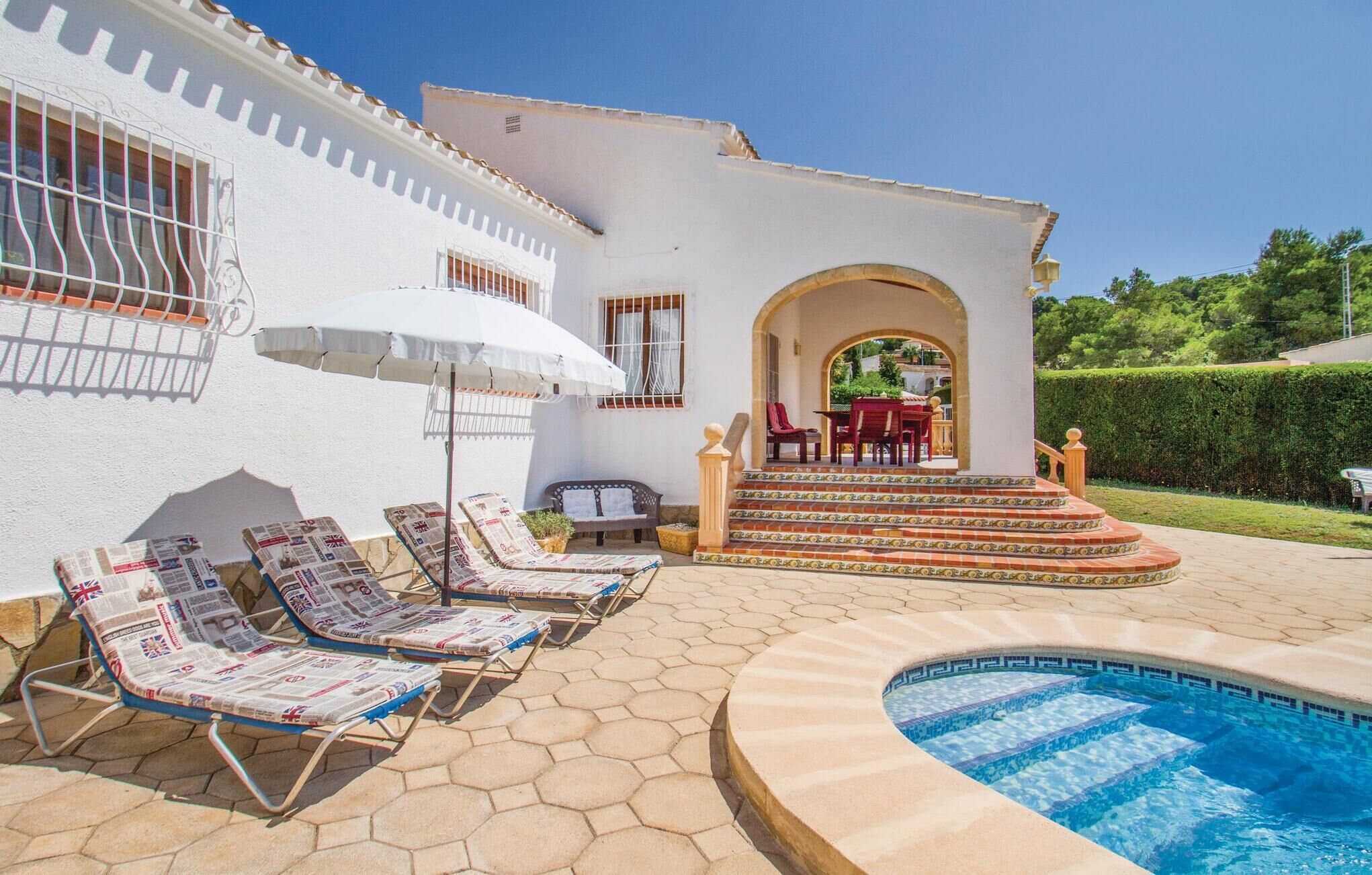 A pool area with lounge chairs, a small patio with a table and chairs, and a clear blue swimming pool.
