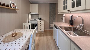 A compact kitchen with a stove, sink, and cabinets.