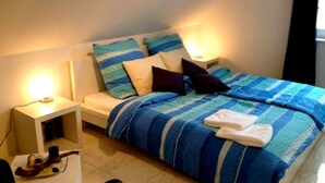 A bedroom with a bed, two bedside tables, and a nightstand. - Apartment 2 - Cozy in the attic - Apartment Burgert Family (Patzig)