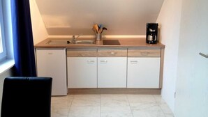 A compact kitchen with a sink, a coffee maker, and a cabinet. - Apartment 2 - Cozy in the attic - Apartment Burgert Family (Patzig)