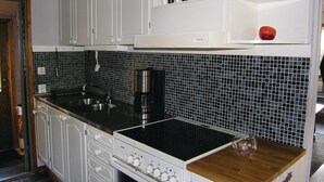 A kitchen with white cabinets, a black tiled backsplash, and a Bosch stove. - 2 bedroom stunning home in Unnaryd (Unnaryd)