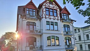 Ein mehrgeschossiges Gebäude im traditionellen Baustil, mit Balkonen und großen Fenstern.