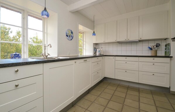 Kitchen features a sink, modern faucet, and ample storage.