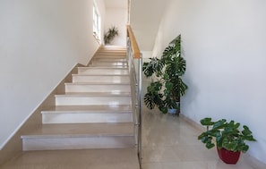A staircase with a handrail, leading to a landing with potted plants. - Beach front apartment in Makarska (Makarska)