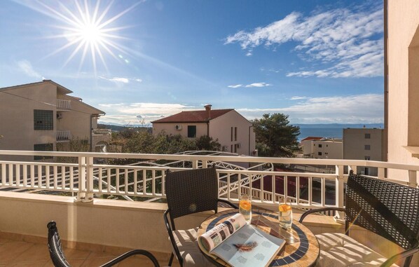 Ein Balkon mit Tisch, Stühlen und einer Zeitschrift.