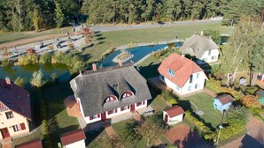Un quartier résidentiel avec des maisons, un étang et un terrain de jeux.