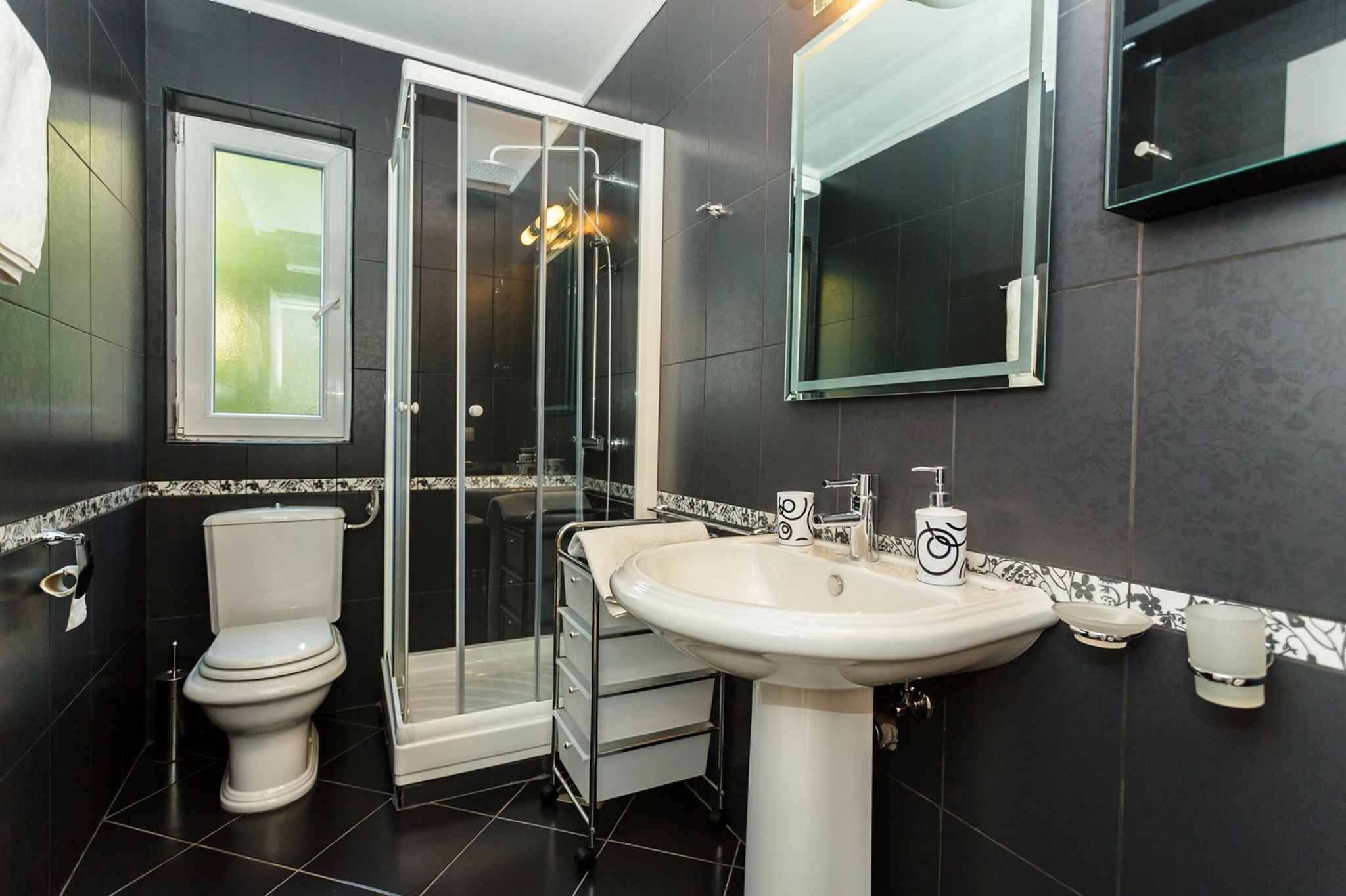 Un bagno moderno con WC, doccia e lavandino.