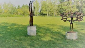 Two metal sculptures in a grassy field.