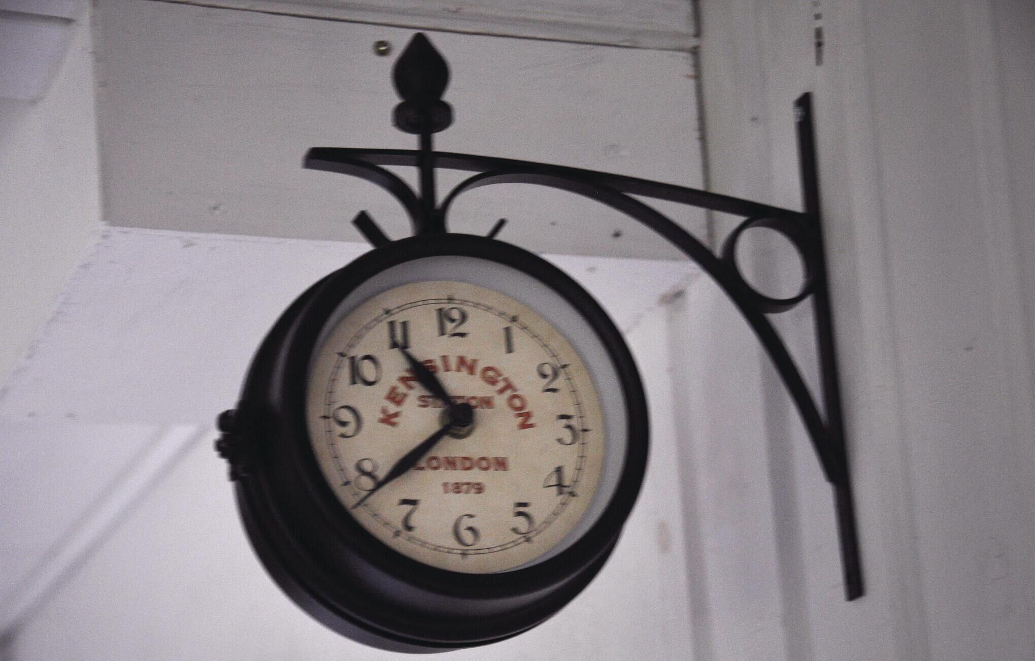 Een aan de muur bevestigd horloge met een retro ontwerp, met de merknaam en het jaartal.