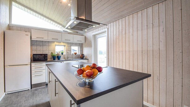A modern kitchen with a central island, built-in appliances, and wooden paneling. - Gorgeous home in Ejstrupholm with sauna (Ejstrupholm)