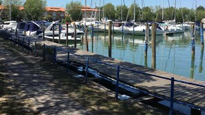 Ein Yachthafen mit vertäuten Booten, eine Holzsteganlage und ein klarer, blauer Himmel.