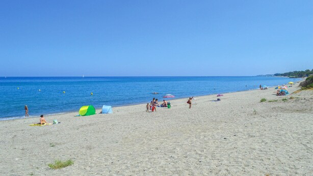 A beach with clear skies, calm water, and people relaxing. - Stunning home in Moriani Plage (Moriani Plage)