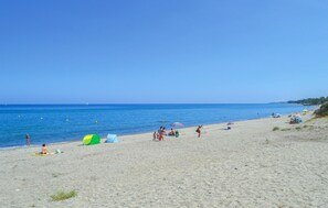 A beach with clear skies, calm water, and people relaxing. - Stunning home in Moriani Plage (Moriani Plage)