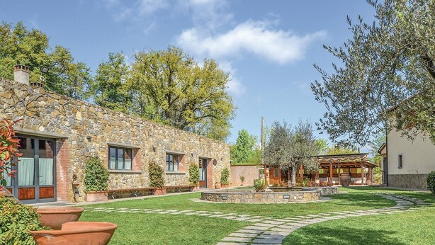 A stone building with a stone pathway leading to a covered seating area.