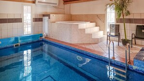 An indoor swimming pool with clear blue water, a hot tub, and a staircase leading to a higher level. - Amazing home in Köpingsvik with sauna (Köpingsvik)