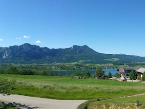 Un paysage rural avec une montagne, un lac et quelques bâtiments.