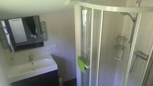 A bathroom with a shower, sink, and mirror.