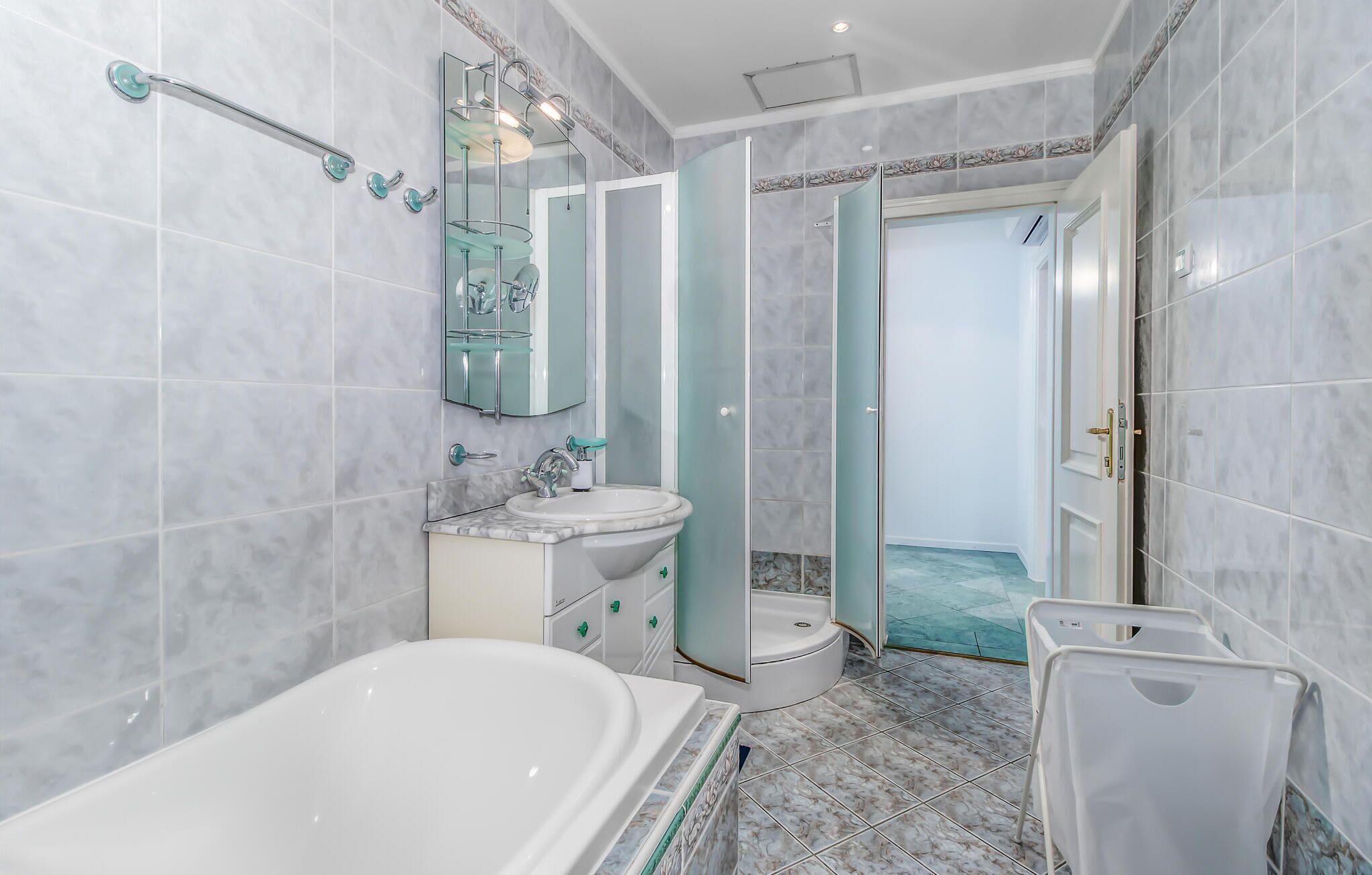 A modern bathroom with a bathtub, sink, and toilet.