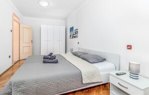 A bedroom with a bed, a nightstand, a lamp, and a wardrobe. - Gorgeous home in Dramalj (Dramalj)