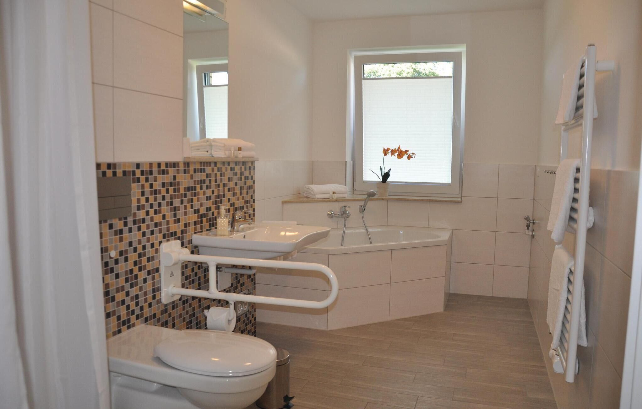 A modern bathroom with a toilet, sink, and bathtub.