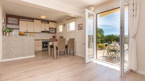 Una cocina moderna con comedor y puerta corrediza de vidrio que da a un patio.