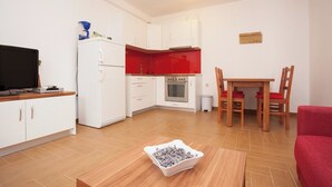 Un espacio habitable compacto con kitchenette, zona de comedor y área de estar.