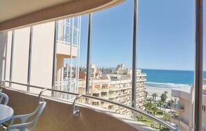 A balcony with a view of the ocean and adjacent buildings. - Lovely apartment in Canet en Roussillon (Canet en Roussillon)