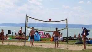 Un partido de voleibol de playa con jugadores y espectadores.