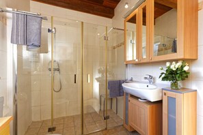 Een douche, handdoeken, zeep, toiletpapier