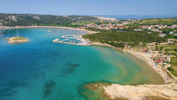 An aerial view of a coastal town with clear waters, a marina, and a beach. - Holiday apartment with terrace (Kampor)