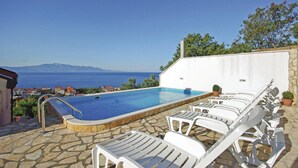A pool with white lounge chairs, a stone patio, and a view of the sea and mountains. - 1 bedroom awesome apartment in Podaca (Podaca)