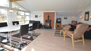 A spacious living area with a fireplace, modern furniture, and large windows. - Cozy home in Løkken with sauna (Løkken)