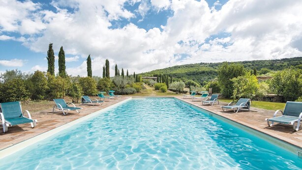 A rectangular swimming pool with clear blue water, surrounded by lounge chairs and greenery. - Stunning apartment in San Vito in Monte TR with outdoor swimming pool (San Vito in Monte TR)