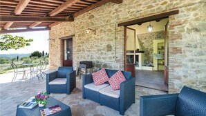 An outdoor seating area with wicker furniture, a grill, and a view of the countryside. - Stunning apartment in San Vito in Monte TR with outdoor swimming pool (San Vito in Monte TR)