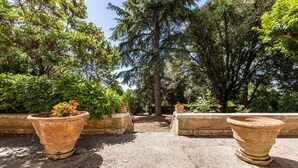 A garden pathway with terracotta planters and a brick wall. - Amazing home in Capannoli PI with WiFi (Capannoli PI)