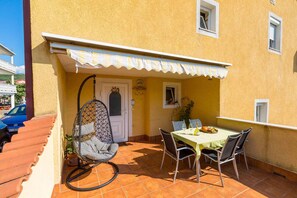 Enjoy a romantic meal for two in this charming outdoor dining area with a table set and comfortable seating.