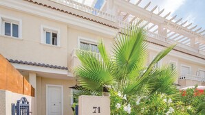 Un edificio a più piani con facciata chiara, un balcone con ringhiera bianca e una porta con il numero 71.
