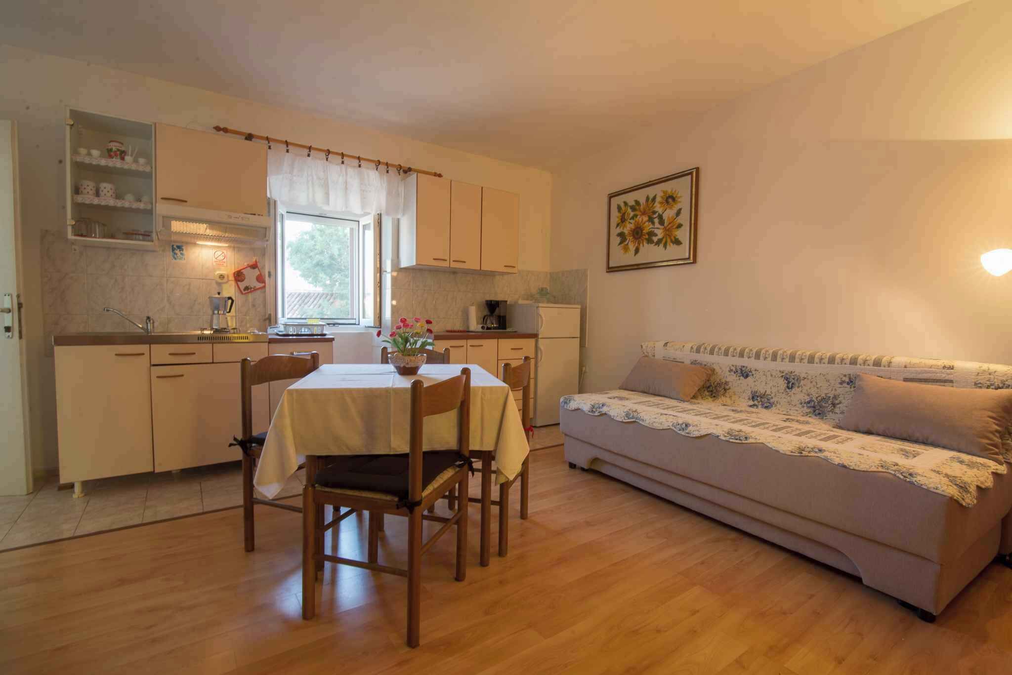 Un espacio habitable compacto con comedor, kitchenette y sofá.
