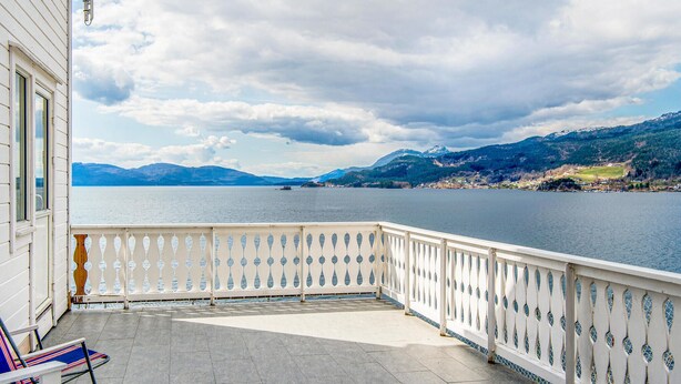 Un balcon avec vue sur un lac et des montagnes.