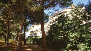 A building with multiple balconies, surrounded by trees and a dirt path. - Gorgeous apartment in Argeles sur Mer (Argeles sur Mer)