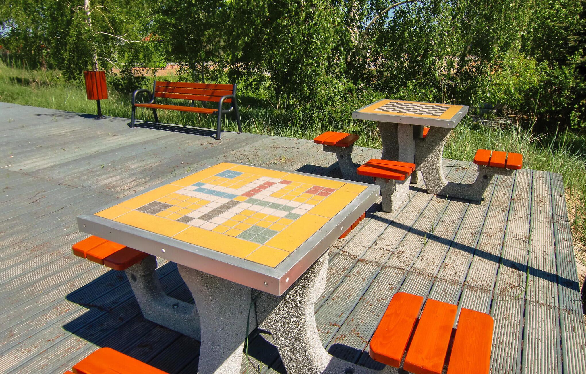 A park bench and a chess table with benches around it.