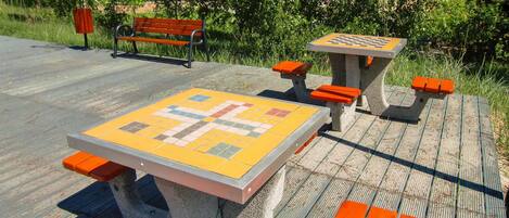 A park bench and a chess table with benches around it.