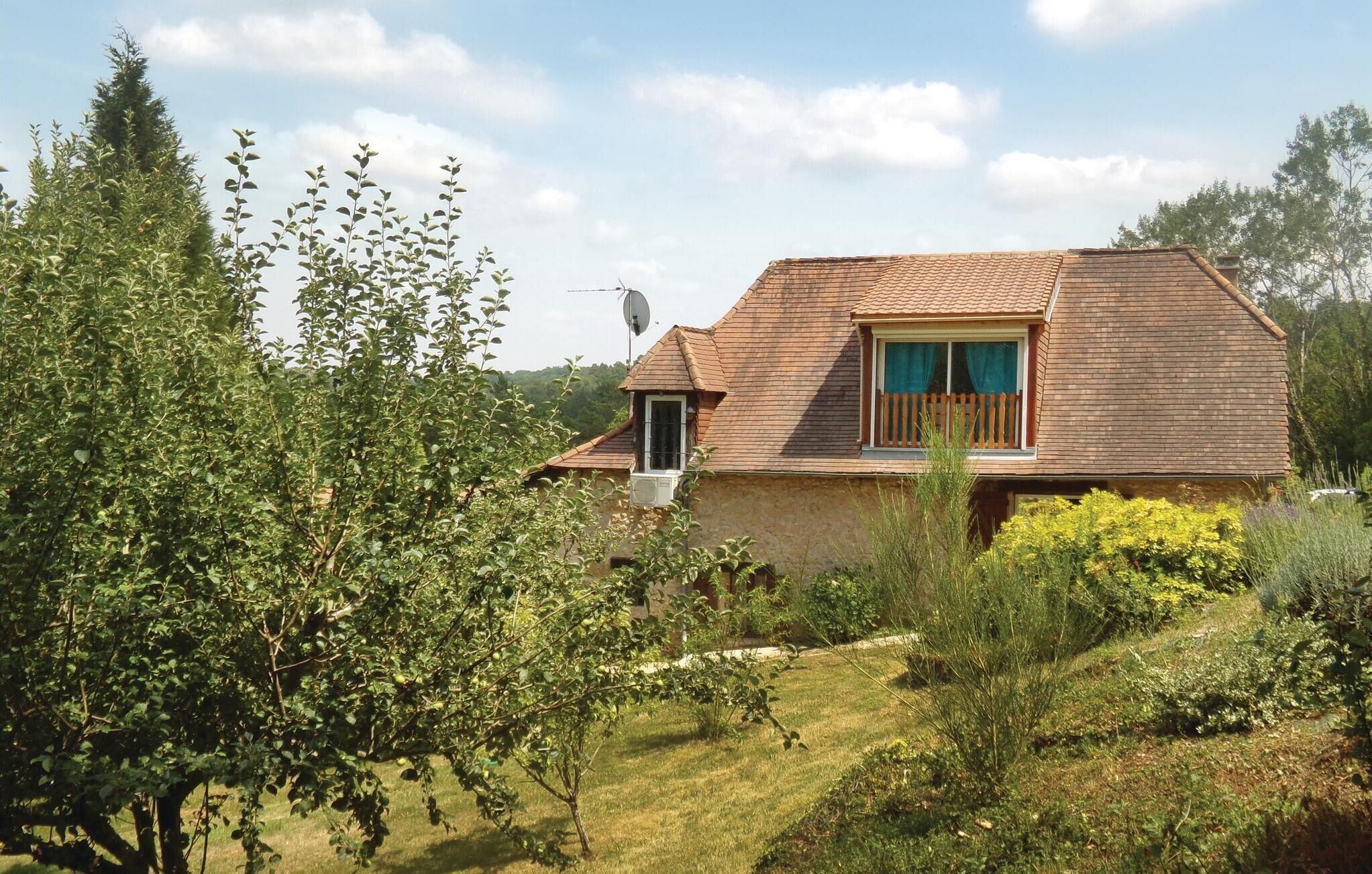 Ein zweistöckiges Haus mit geneigtem Dach, einer Satellitenschüssel und einem kleinen Balkon.