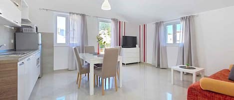 A modern apartment with a kitchen, dining area, and living room.