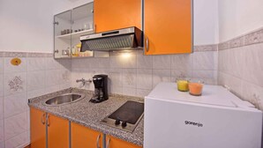 A compact kitchen with a built-in stove, a coffee maker, and a refrigerator. - Studio with pool and air conditioning (Novigrad)