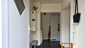 A hallway with a bench, a wooden table, and a refrigerator. - Vacation apartment 2 - Green idyll (Borrentin)