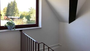 Ein Fenster mit Blick auf Bäume und ein Gebäude.