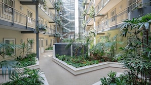 Un atrio a più livelli con un giardino centrale, balconi e un soffitto in vetro.